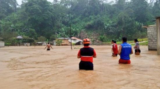 Personal de Riesgos y habitantes de Cumandá en una zona afectada por severas inundacionees, el 4 de marzo de 2024.