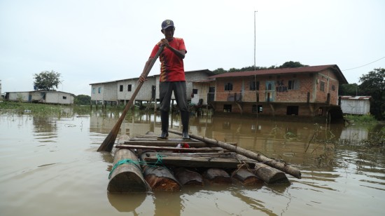 José Chichande, habitante del sector El Palmar, en la vía Babahoyo-Montalvo, ingresa y sale de su casa en una plataforma improvisada tras un mes de inundaciones en el sector.