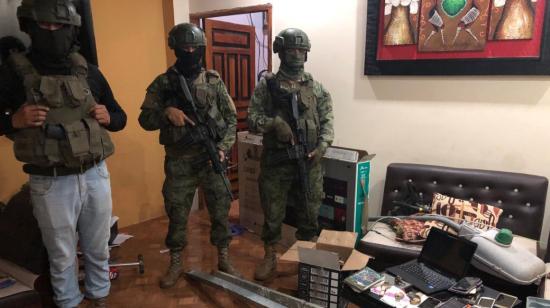 Militares junto a varias de las evidencias encontradas en una vivienda de Portoviejo, usada por la banda Los Lobos, el 14 de marzo de 2024.