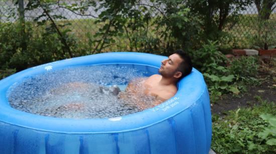 Imagen referencial de un hombre sumergido en una piscina inflable con hielos. 