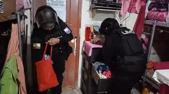 Dos policías revisando una celda en la cárcel de Chillogallo, sur de Quito, el 19 de marzo de 2024.