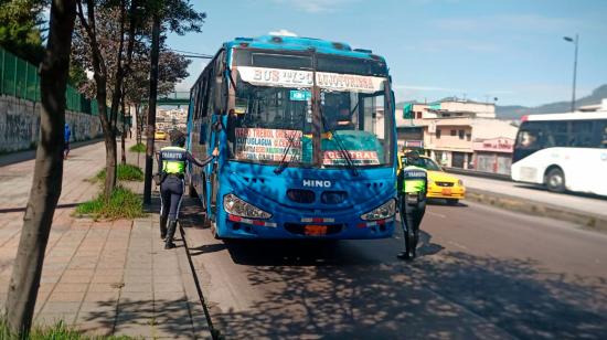 Agentes de tránsito realizan un operativo de control a un bus en Quito.