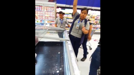 Trabajadores de un supermercado en Guayaquil retiran las rejillas de un congelador, lleno de plagas, el 26 de marzo de 2024.