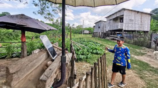 En el recinto Don Lucas, al interior de la provincia de Santa Elena, un celular bajo un paraguas funciona como teléfono público de los 60 habitantes. 