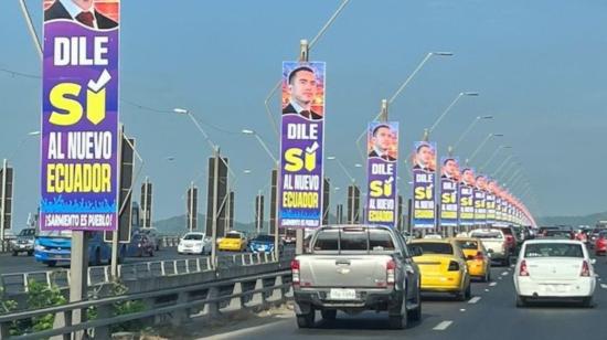 Carteles con la imagen del presidente Daniel Noboa promoviendo el SÍ en la consulta popular cuelgan de los postes del Puente de la Unidad Nacional, en Guayaquil, el 8 de abril de 2024.