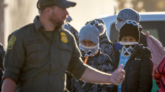 Imagen referencial de migrantes ecuatorianos junto a un oficial de la patrulla fronteriza de Estados Unidos, en la frontera con México, en diciembre de 2023.