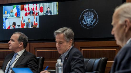 El presidente de Estados Unidos Joe Biden (der.) hablando con líderes del G7, en pantalla, este domingo desde la Casa Blanca en Washington.