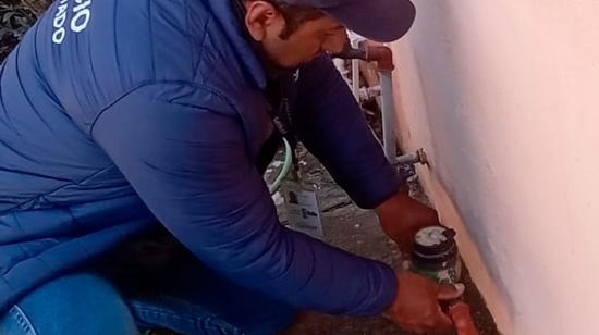 Trabajador de la Empresa de Agua de Quito revisa un medidor de agua en Quito.