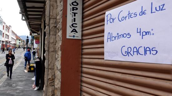 Uno de los locales comerciales en el centro historico de Cuenca, con un aviso sobre los cortes de luz, el 22 de abril de 2024.