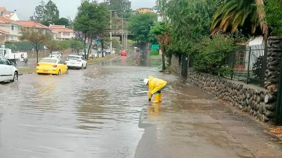 Funcionario de Etapa, en Cuenca, trabaja en una calle inundada, este 24 de abril de 2024.