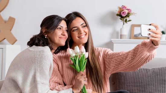 Imagen referencial de una joven que regala flores a su madre.