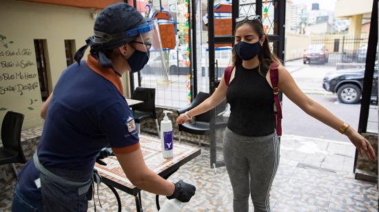 Empleada de un restaurante en Quito mientras desinfecta a una cliente (Ecuador). 26/06/2020