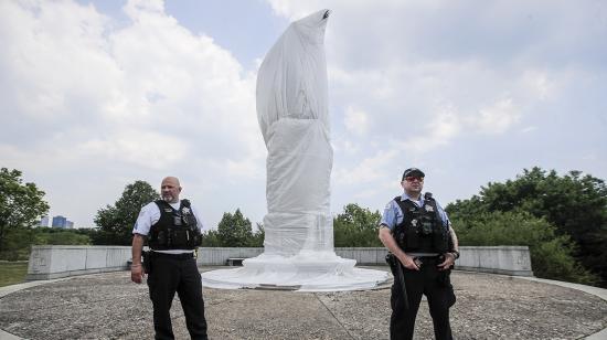 Los oficiales de policía de Chicago hacen guardia en una estatua de Cristóbal Colón desfigurada durante una manifestación de protesta el 15 de junio.