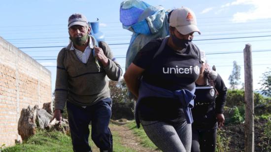 Lorena Erazo, su padre y su hermana cargan con tanques de gas por una trocha entre Tulcán (Ecuador), y la localidad colombiana de Ipiales. 26 de julio de 2020