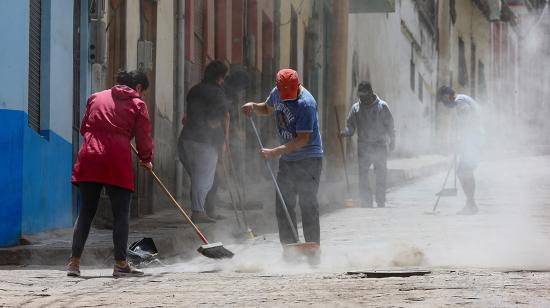 Habitantes barren hoy la ceniza del volcán Sangay en una calle de Alausí, en la provincia de Chimborazo (Ecuador). 20/09/2020 