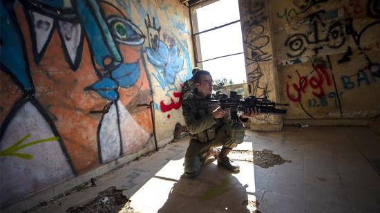 Un soldado israelí apunta con su arma durante el entrenamiento a un edificio abandonado que solía ser el cuartel general del ejército sirio en Quneitra antes de que fuera tomado por Israel, en los Altos del Golán, el 15 de febrero. 2021.