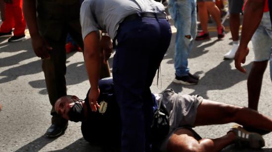 Un hombre permanece en el suelo mientras es arrestado durante protestas frente al Capitolio, en La Habana (Cuba). 11/07/2021