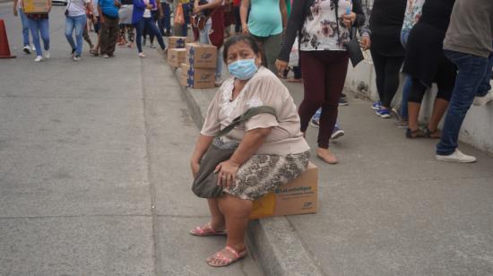 Celia Caicedo de 58 años, con una caja de alimentos afuera del centro de vacunación Mucho Lote, en Guayaquil. 28 de julio de 2021.