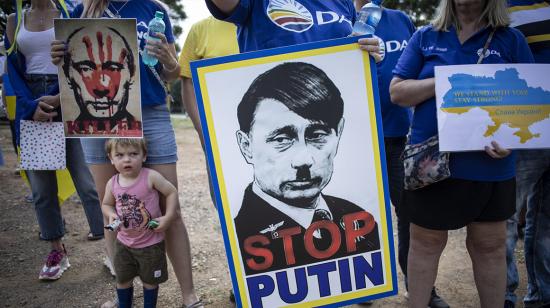 Un manifestante sostiene una pancarta que representa una caricatura del presidente ruso Putin mientras escucha los discursos durante una manifestación por la paz contra la invasión rusa de Ucrania, en Pretoria, Sudáfrica, el 11 de marzo de 2022.