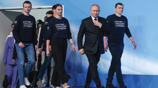 En esta fotografía de grupo distribuida por la agencia estatal rusa Sputnik, el presidente y candidato presidencial ruso Vladimir Putin se reúne con sus confidentes y voluntarios en su sede de campaña en Moscú el 17 de marzo de 2024. 