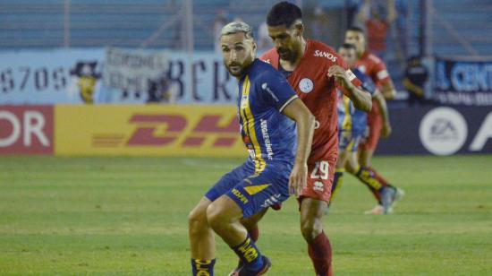 Juan Manuel Elordi del Delfín y Franco Jara del Belgrano luchan por el balón durante un partido de la Copa Sudamericana.