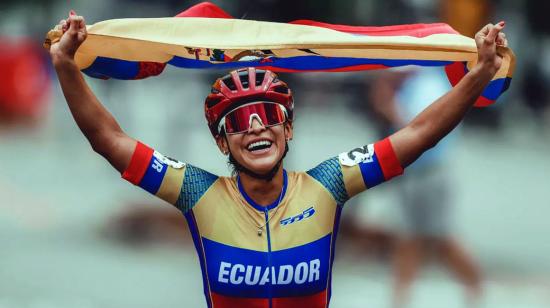 La patinadora, Gaby Vargas, tras lograr un triunfo en patinaje, celebra con la bandera de Ecuador.