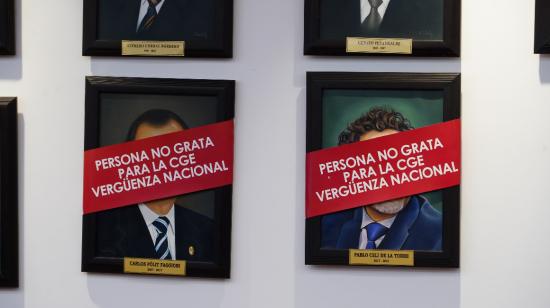 Los retratos de los excontralores Pablo Celi y Carlos Pólit aparecen cubiertos en el edificio de la Contraloría, en Quito, el 21 de mayo de 2024.