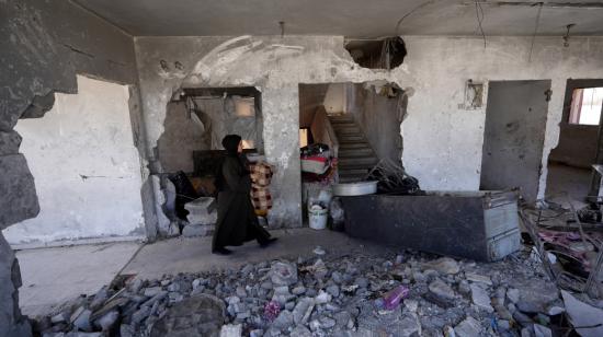 Una mujer camina junto a una vivienda bombardeada en Rafah, sur de Gaza, y centro de los ataques de Israel, 29 de mayo de 2024.