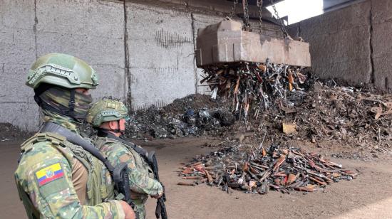 Dos militares custodian la destrucción de miles de armas en las instalaciones de Andec, 30 de mayo de 2024.