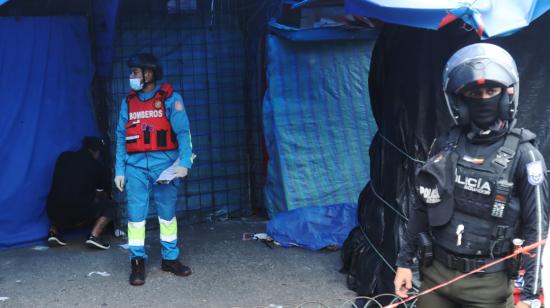 Miembros de Bomberos y de la Policía junto a uno de los fallecidos en el mercado de Guayaquil, 3 de junio de 2024.