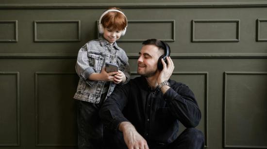 Fotografía referencial de un niño escuchando música junto a su padre.