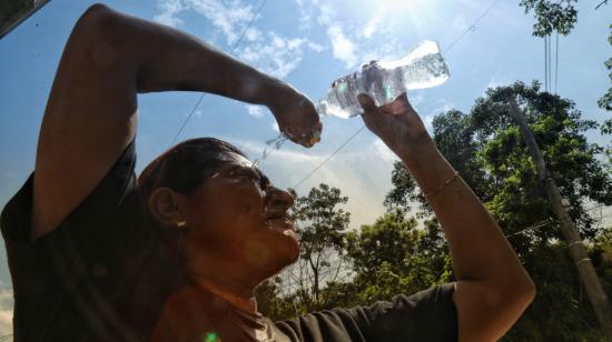 Una persona con agua por el calor en Guayaquil, 19 de marzo de 2024.