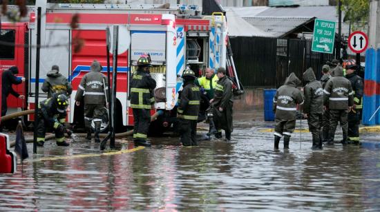 Carabineros y bomberos trabajan en calles inundadas por la lluvia en Santiago de Chile, el 13 de junio de 2024.