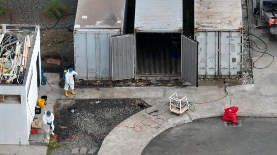 Personal de limpieza desinfecta uno de los contenedores de la morgue de Guayaquil, el 13 de junio de 2024.