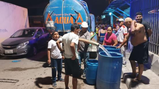 Habitantes de la vía a la Costa se abastecen de agua con un tanquero, el 13 de junio de 2024.