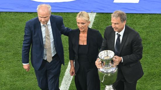 El exfutbolista alemán Bernard Dietz, la viuda del fallecido futbolista alemán Franz Beckenbauer, Heidi Beckenbauer, y el exfutbolista alemán Juergen Klinsmann con el trofeo de la Eurocopa, el 14 de junio de 2024.