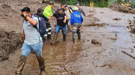 La Policía ayuda a cruzar a varias personas tras el deslave en Baños, Tungurahua, el 16 de junio de 2024.