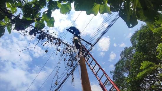 Imagen referencial de un trabajador de CNEL, en un poste de luz, el 11 de abril de 2024.