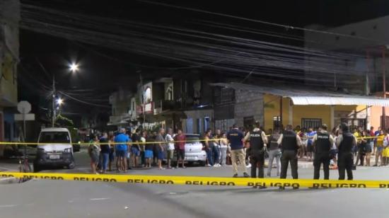 Policías y moradores de Samborondón junto al cuerpo de un hombre acribillado en el cantón, la noche del 17 de junio de 2024.