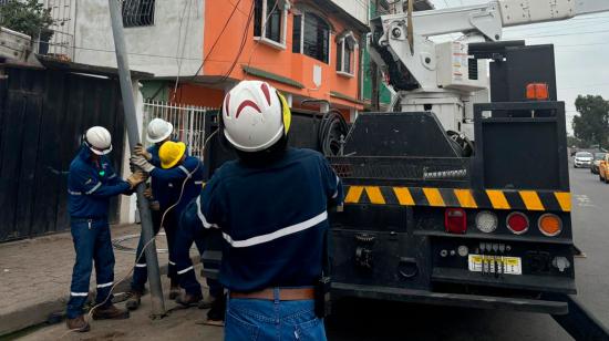 Trabajadores de CNEL realizan cambios de postes en un calle de Durán, en Guayas.