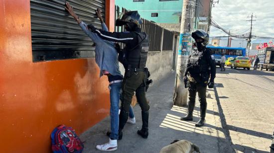 Dos policías registran a un hombre en Quito, en mayo de 2024.