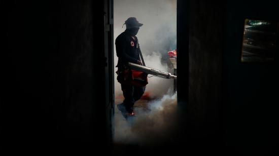 Un integrante de Protección Civil fumiga una vivienda en San Salvador (El Salvador).