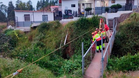Bomberos realizan el rescate de dos personas que cayeron a una quebrada de Quito.