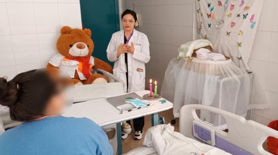 Profesional de la salud acompaña a una madre en el Hospital Vicente Corral Moscoso de Cuenca.