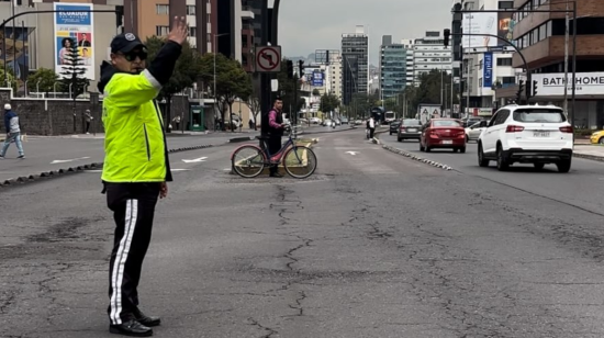 Agente de la AMT dirige la circulación vehicular en las calles de Quito.