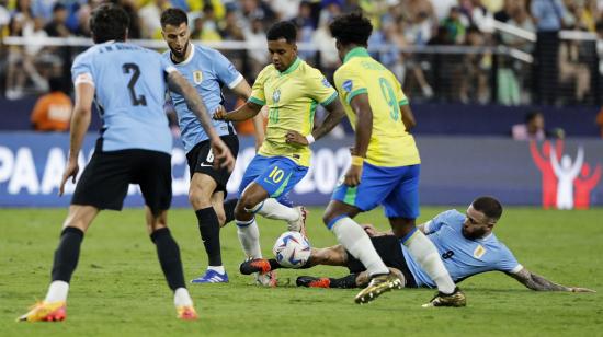 Momento exacto en el que Nahitan Nández se barre por detrás de Rodrygo para impactar su tobillo durante el partido ante Brasil.