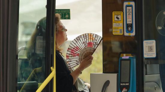 Una mujer se abanica en el interior de un bus de línea del centro de Madrid, 27 de junio de 2024.