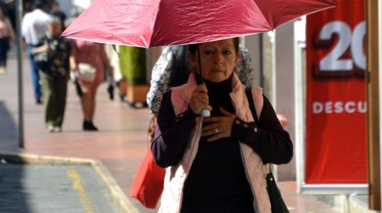 Una mujer camina con una sombrilla para protegerse del calor, el 26 de enero de 2024.