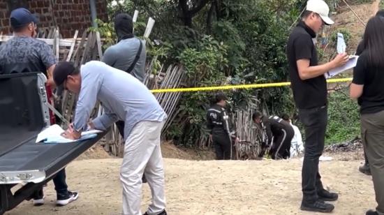 Agentes policiales y de Criminalística en el levantamiento de restos de un hombre en Guayaquil, el 9 de julio de 2024.