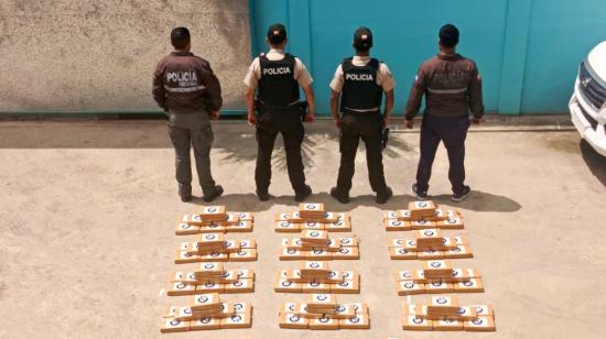 Elementos de la Policía Nacional frente a 140 paquetes de cocaína de tipo ladrillo, incautados en la mañana del 14 de julio de 2024 en una localidad de Esmeraldas, cerca a la frontera con Colombia.